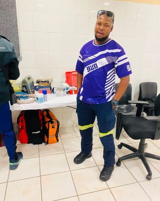A medic in a purple 920 shirt in a medical room