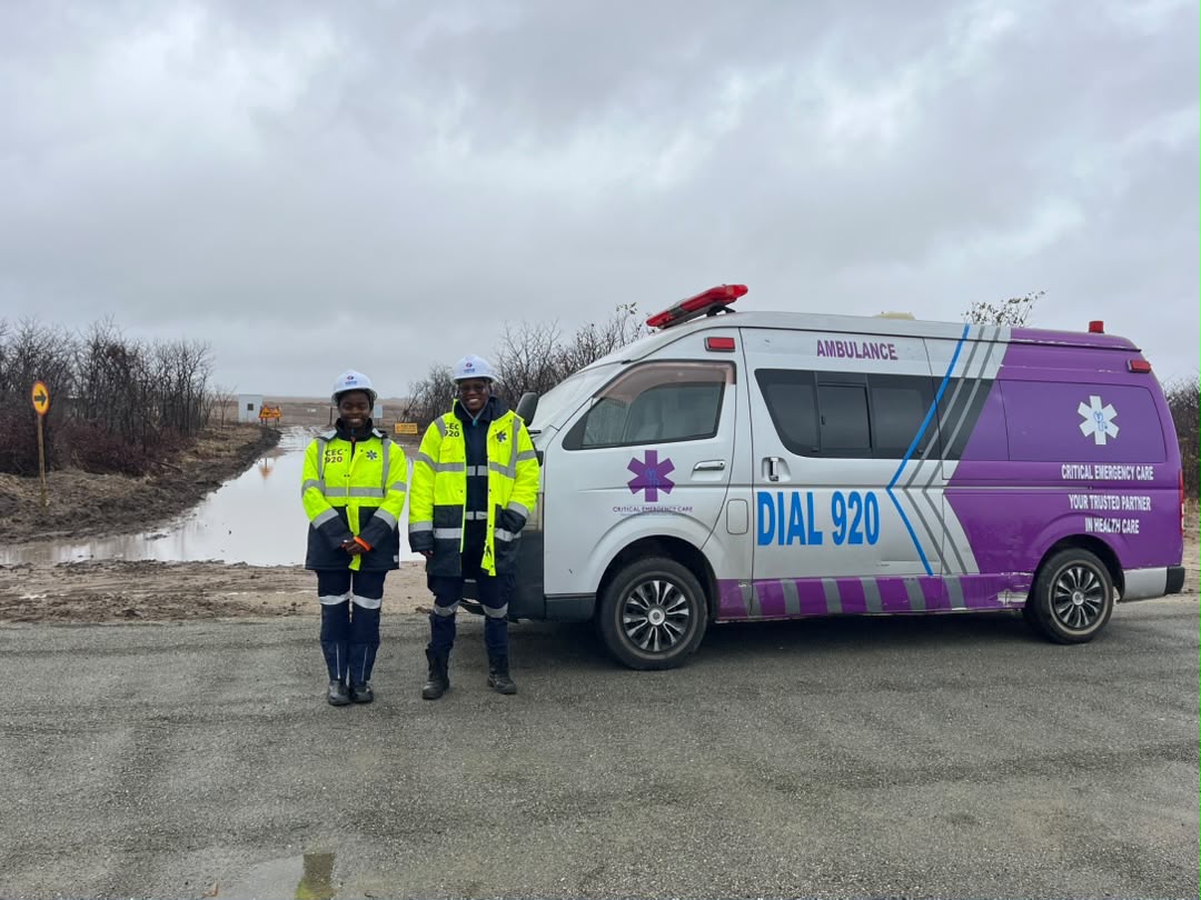 Two medics beside a Dial 920 ambulance at a mine site
